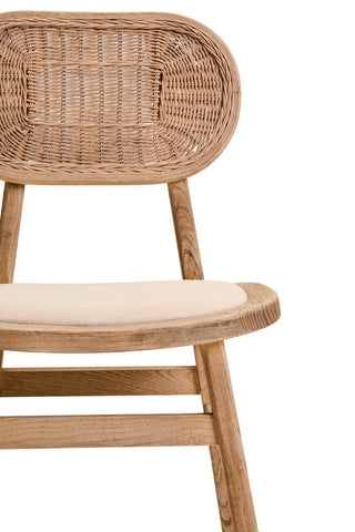 Natural wood dining chair with woven rattan backrest and cream fabric seat, close up