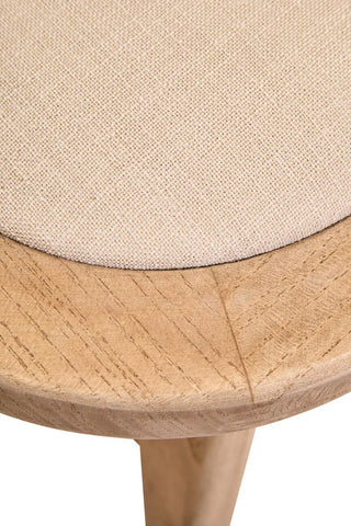 Close-up of beige fabric upholstered wooden stool seat with natural wood grain detail