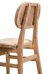 Light oak dining chair with cream cushioned seat and curved rattan backrest, side view