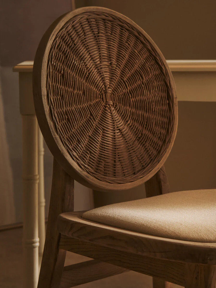 Wood dining chair with round woven rattan backrest and beige cushioned seat