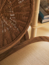 Closeup of rattan dining chair backrest and beige fabric seat cushion