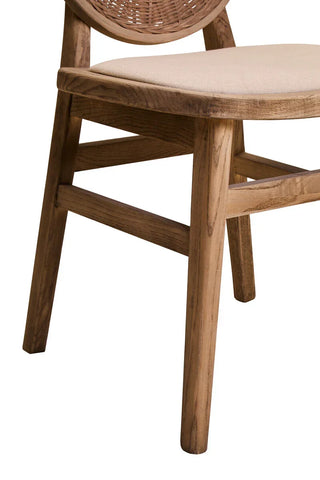 Wooden dining chair with beige cushioned seat and woven backrest, close-up side view