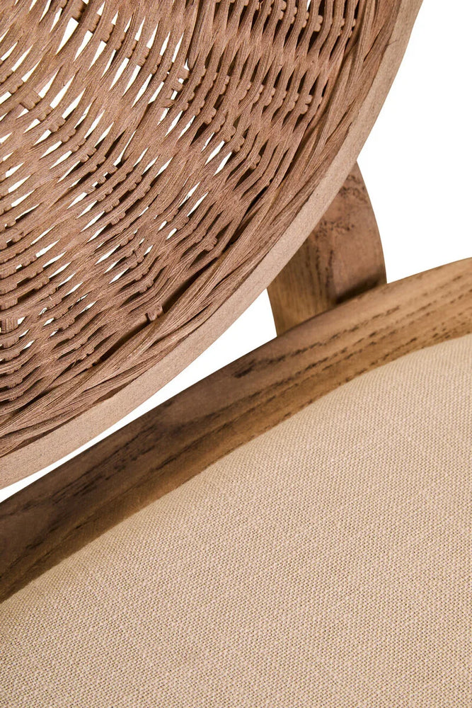 Close up of woven rattan chair back and beige fabric seat cushion