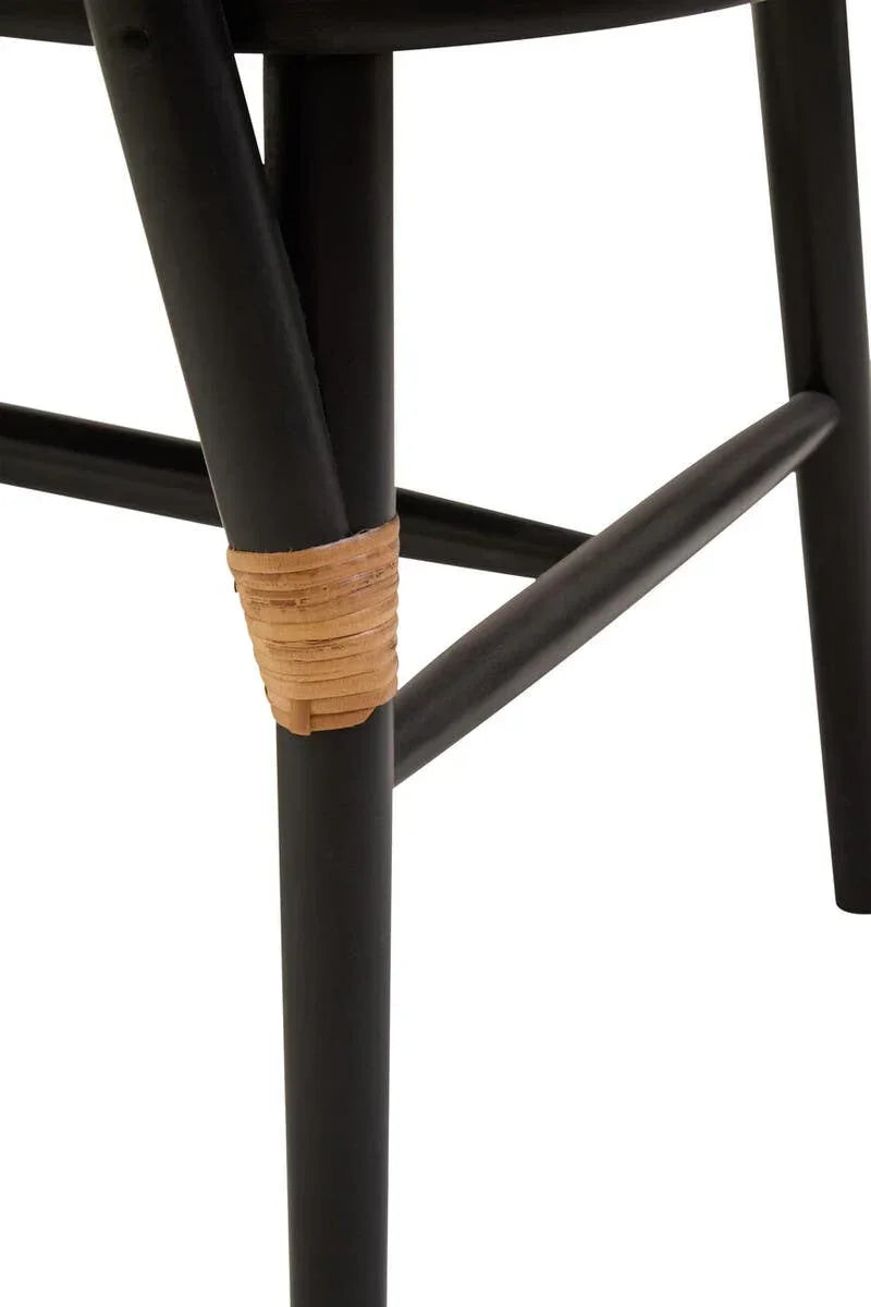 Black chair leg with natural rattan wrap detail and crossbar support