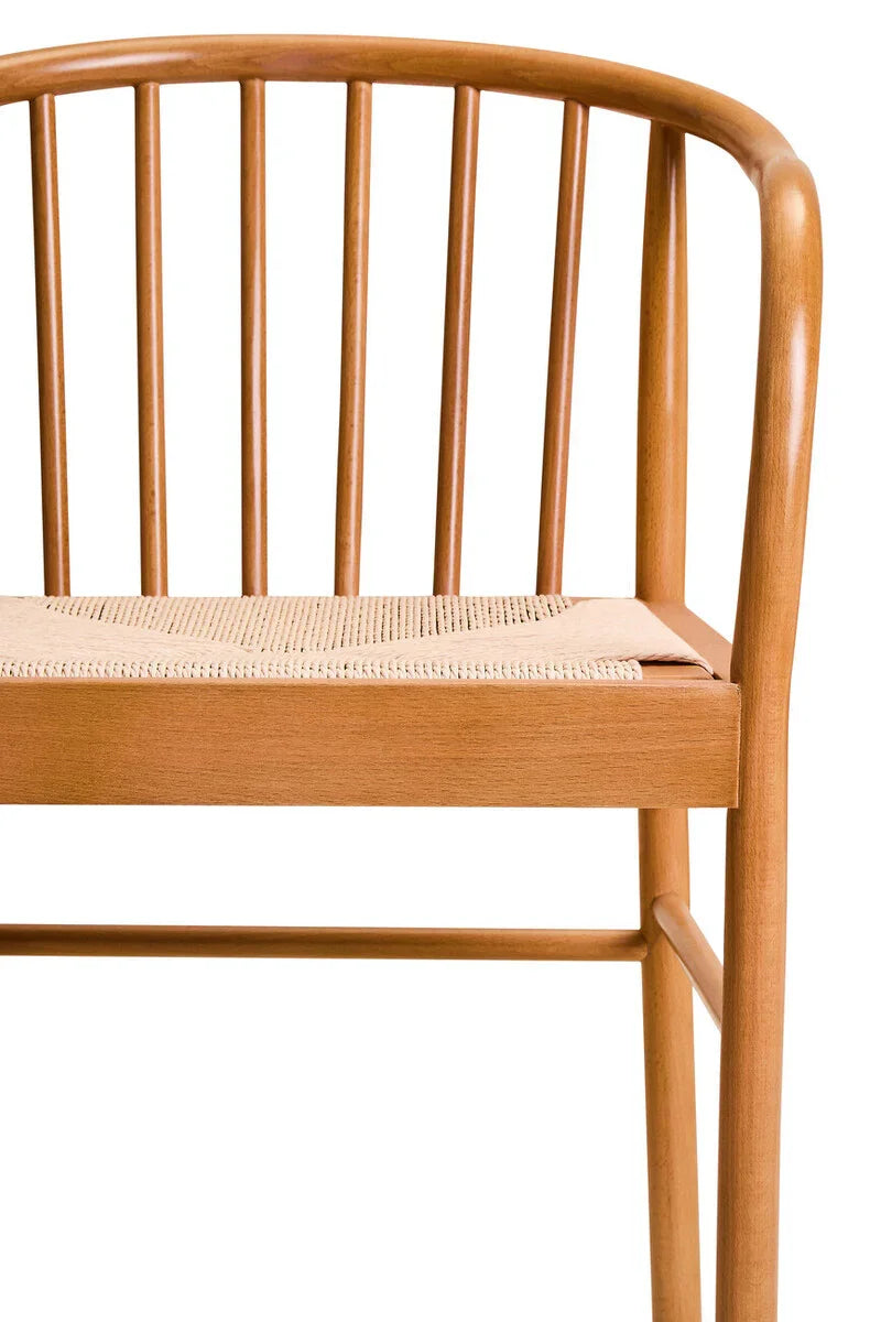 Wooden dining chair with spindle backrest and woven seat, close-up front angle