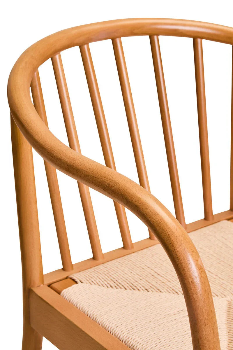 Wooden dining chair with curved spindle back and woven seat closeup