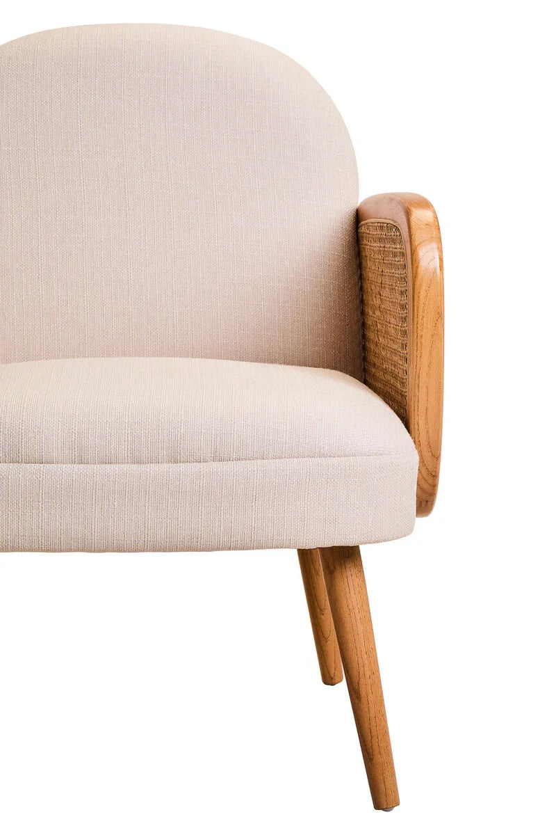 Beige upholstered armchair with wooden armrest and angled wooden legs, close side view