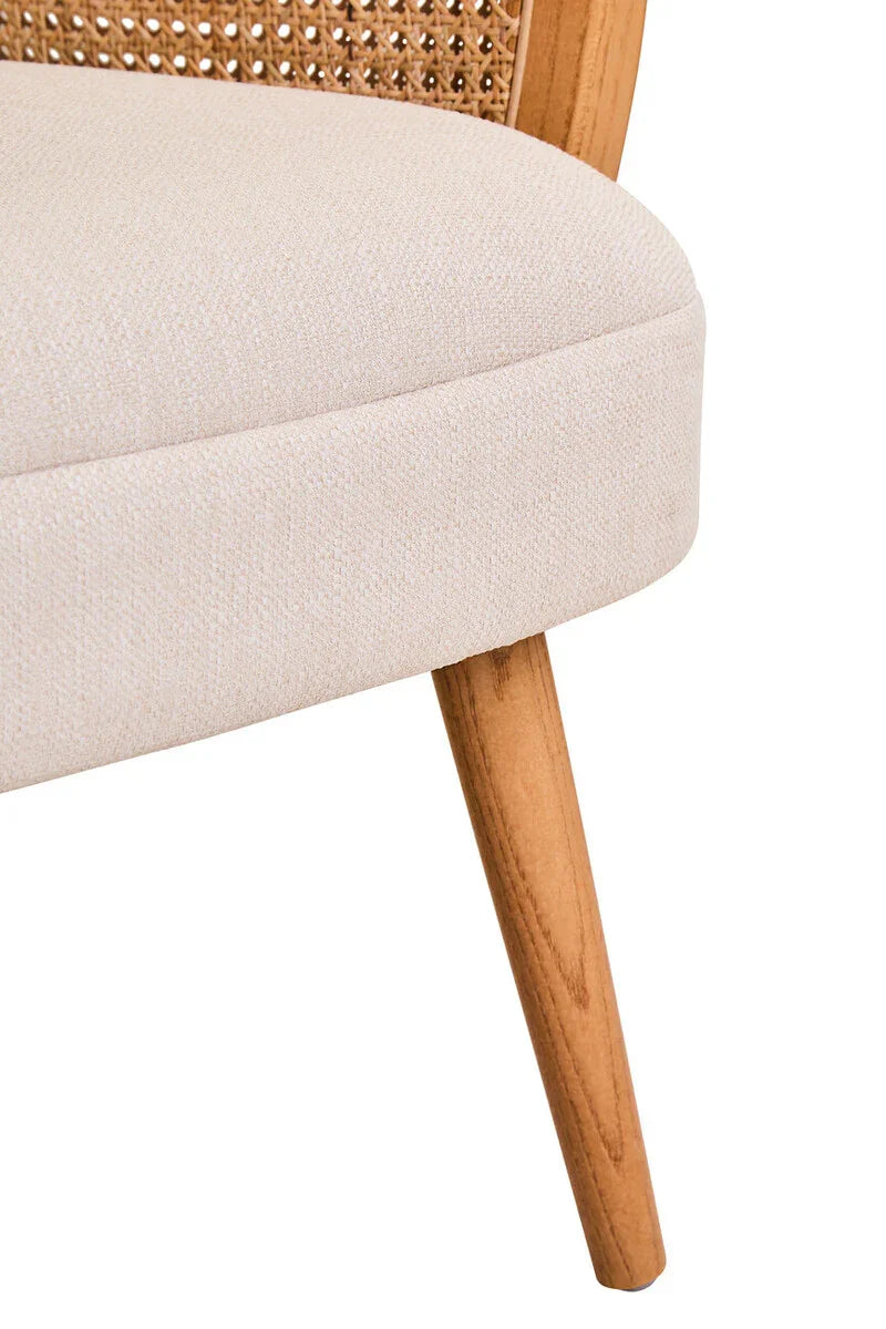 Close-up of beige fabric dining chair seat, natural wood leg and cane backrest