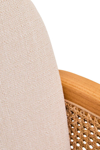 Close-up of beige fabric armchair backrest with wooden frame and woven cane panel
