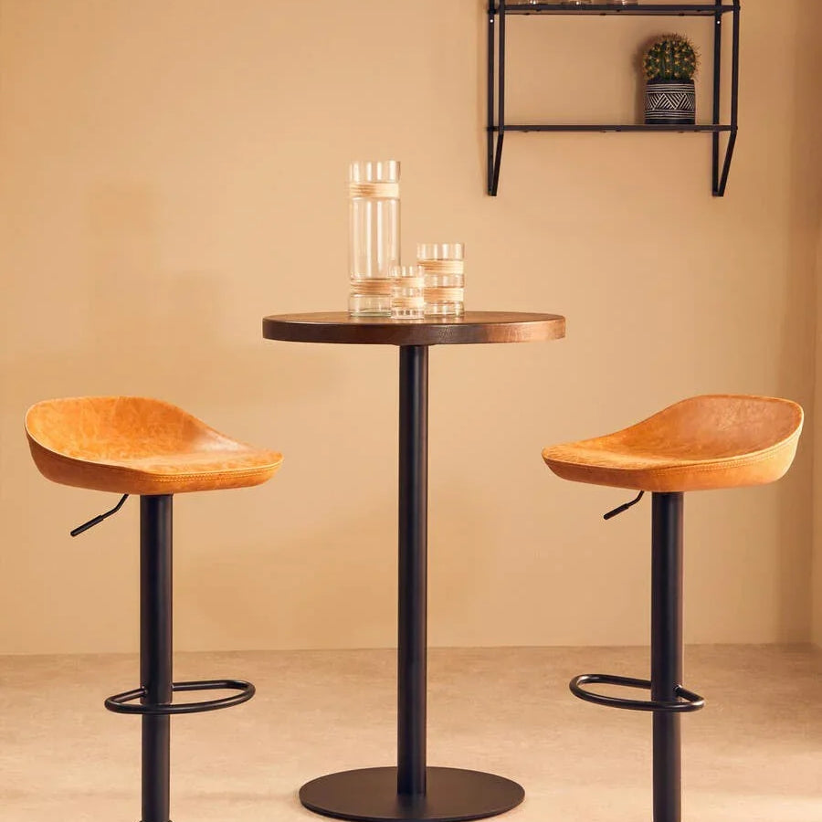Two tan bar stools with black metal bases and round pub table in modern kitchen setting