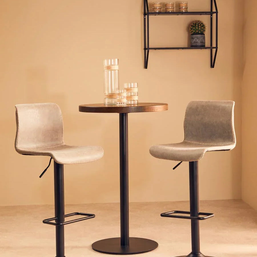 Beige bar stools with black metal bases and round table in modern dining set