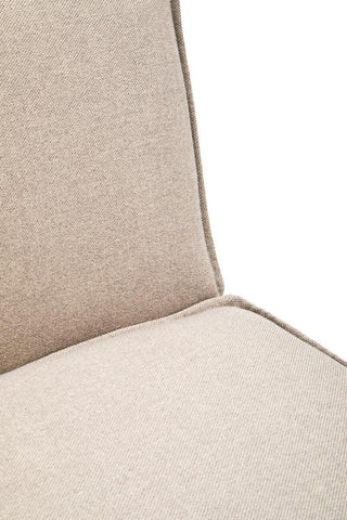 Close-up view of the Toulouse Natural Fabric Armless Modular Sofa, showcasing the soft beige fabric upholstery and clean lines of the backrest and seat cushion, highlighting the minimalist design and stitching details