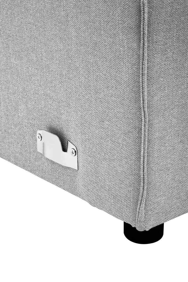 Close-up view of the corner of a grey fabric modular sofa, featuring a sleek design with a visible metal connector and a black leg. The fabric has a soft texture, and the overall color is a light grey
