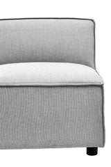 Armless modular sofa in a soft grey fabric with a clean, modern design, featuring a low backrest and a cushioned seat, resting on round black legs