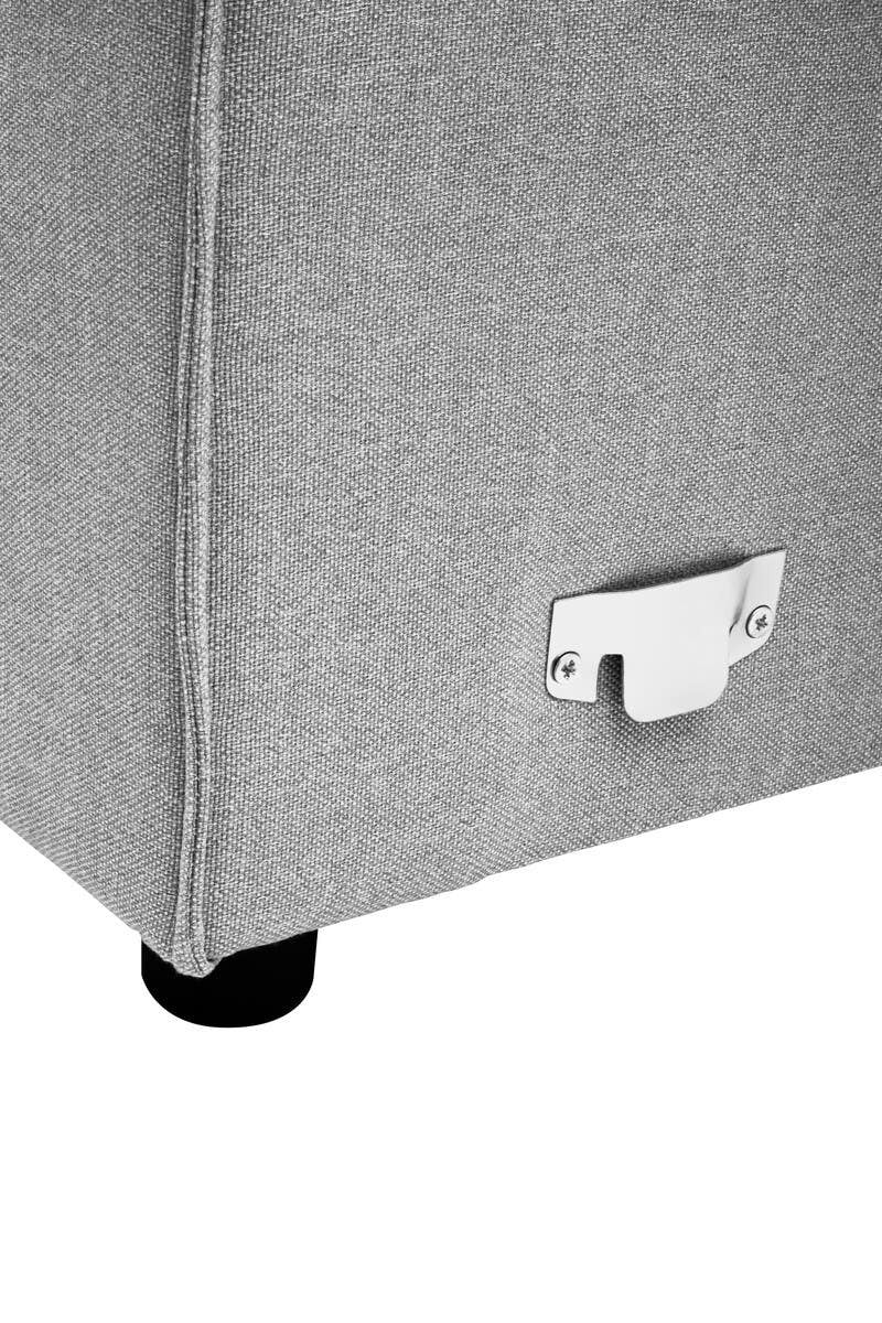 Close-up view of the bottom corner of a grey fabric modular sofa, featuring a sleek design with a silver metal connector and a black plastic foot for stability