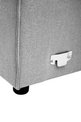 Close-up view of the bottom corner of a grey fabric modular sofa, featuring a sleek design with a silver metal connector and a black plastic foot for stability