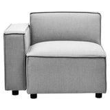 Left arm modular sofa in a soft grey fabric, featuring a minimalist design with a low back and a wide seat cushion. The armrest is square and slightly elevated, complemented by short, sturdy legs. The overall look is modern and versatile, suitable for various living spaces