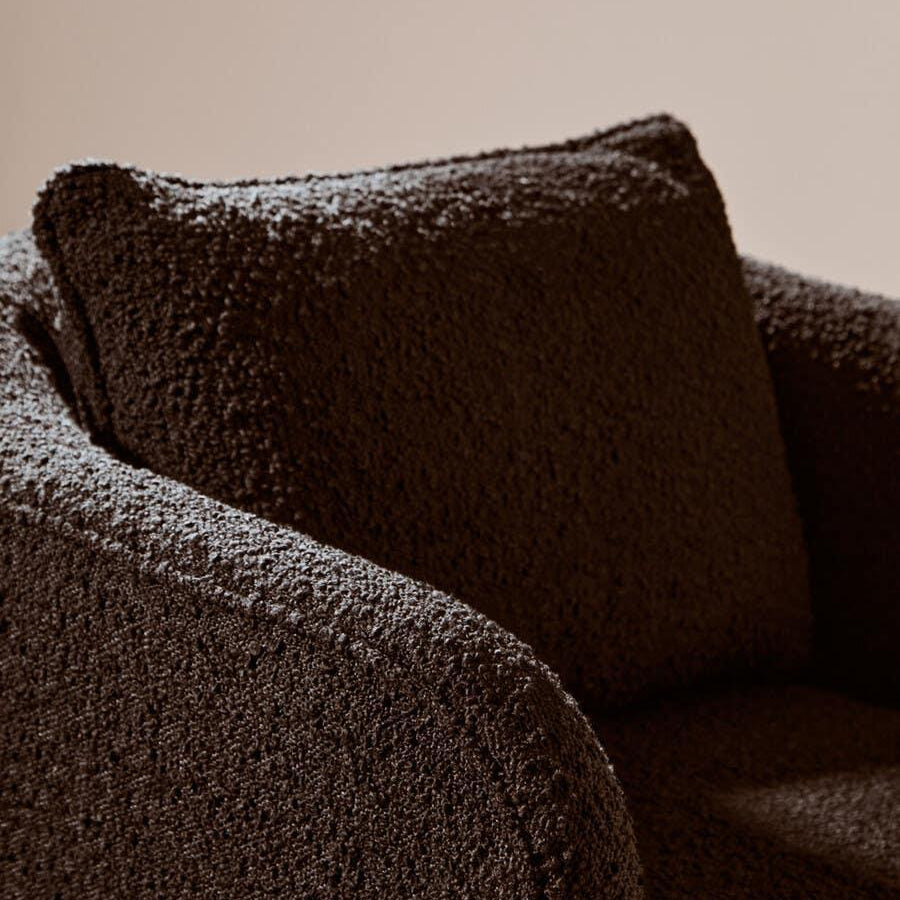 Close-up of brown boucle sofa arm and cushion