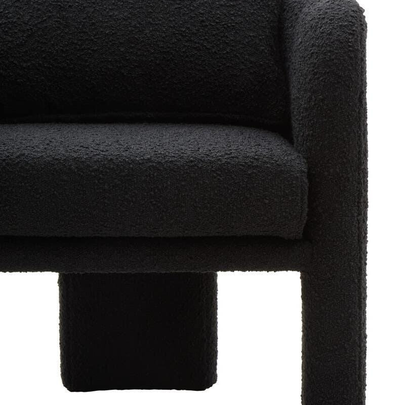 Close-up of black boucle fabric sofa with curved armrest and cushion detail