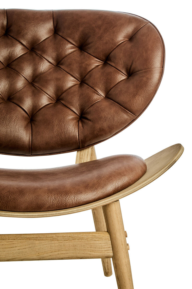 Brown leather effect chair featuring a tufted backrest and a smooth seat, supported by a sturdy elm wood frame.