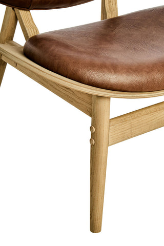 Brown leather effect chair featuring a plush seat and backrest, supported by a light elm wood frame with tapered legs.