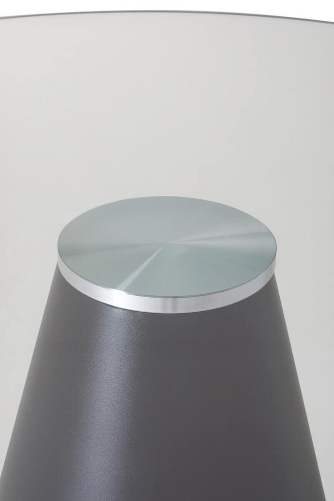 Round glass top side table with metal base, close-up of modern furniture detail