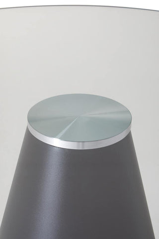 Round glass top side table with metal base, close-up of modern furniture detail