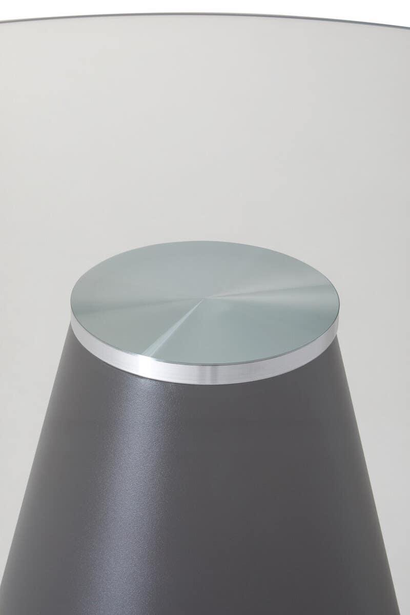 Round glass top side table with metal base, close-up of modern furniture detail