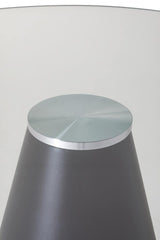 Round glass top side table with metal base, close-up of modern furniture detail