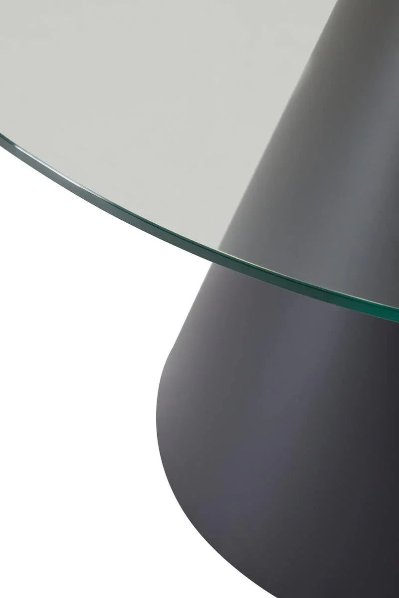 Round glass dining table top with black cone-shaped base, close up on edge and surface