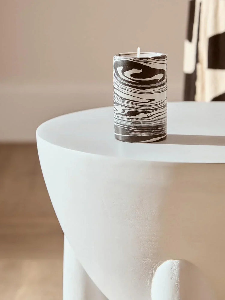 Decorative black and white marble candle on modern white side table