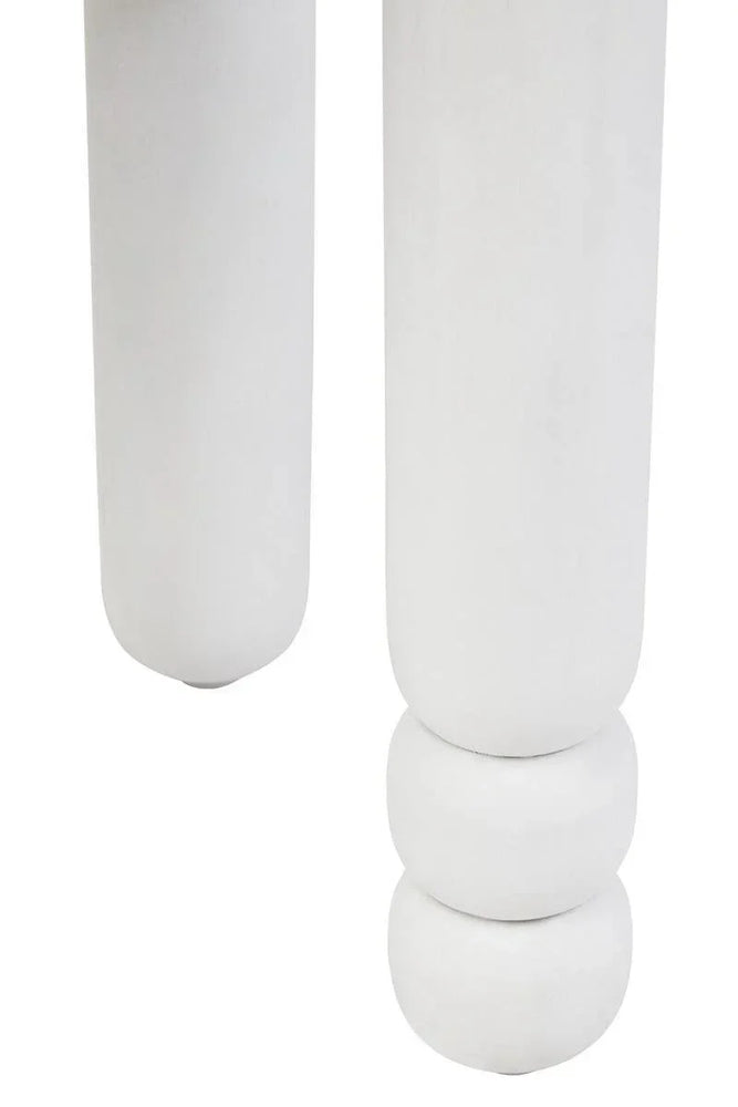 Close-up of white round wooden furniture legs with carved detail
