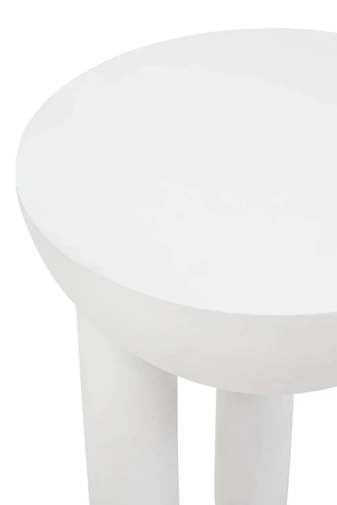 Closeup of round white side table with smooth finish and thick cylindrical legs