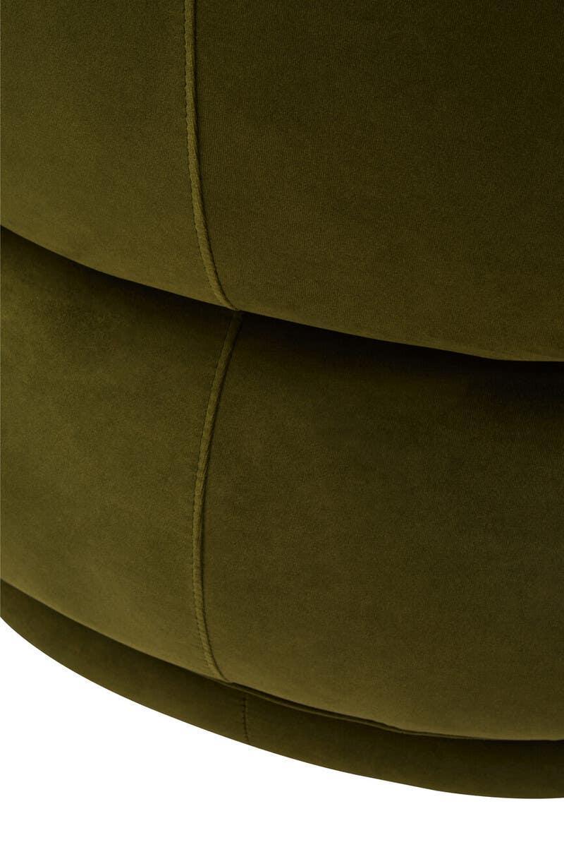 Close-up of green velvet upholstery with visible stitching on curved sofa base