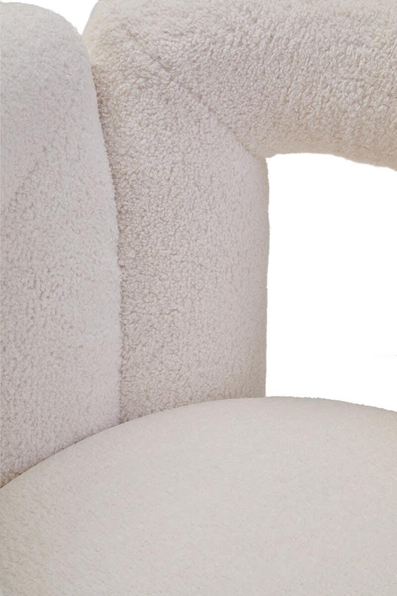 Closeup of cream boucle fabric accent chair with curved backrest and plush seat