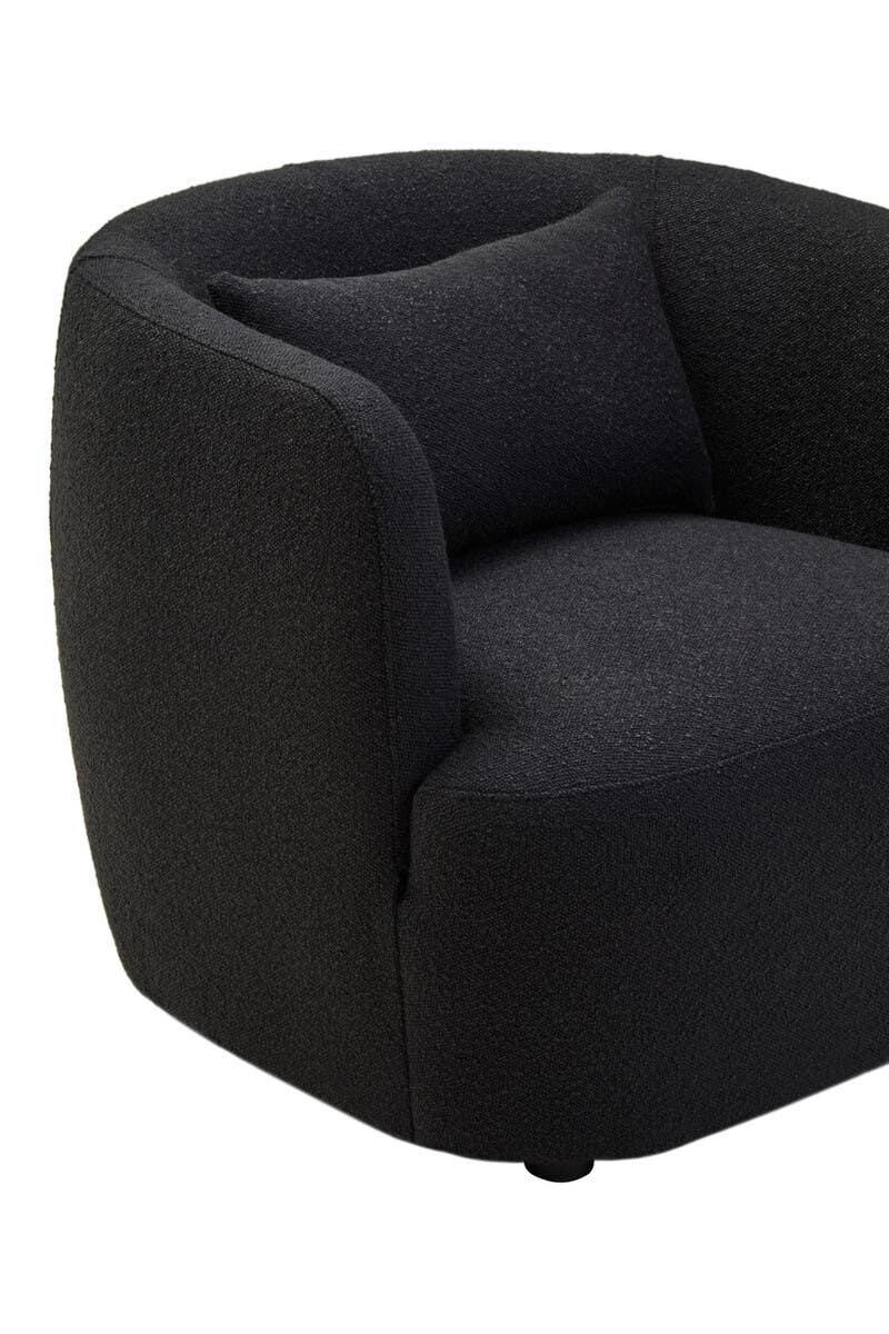 Curved black fabric armchair with matching cushion, close-up of seat and armrest