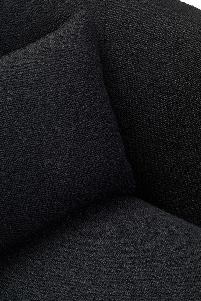 Closeup of black fabric sofa with matching cushion, showing textured upholstery detail