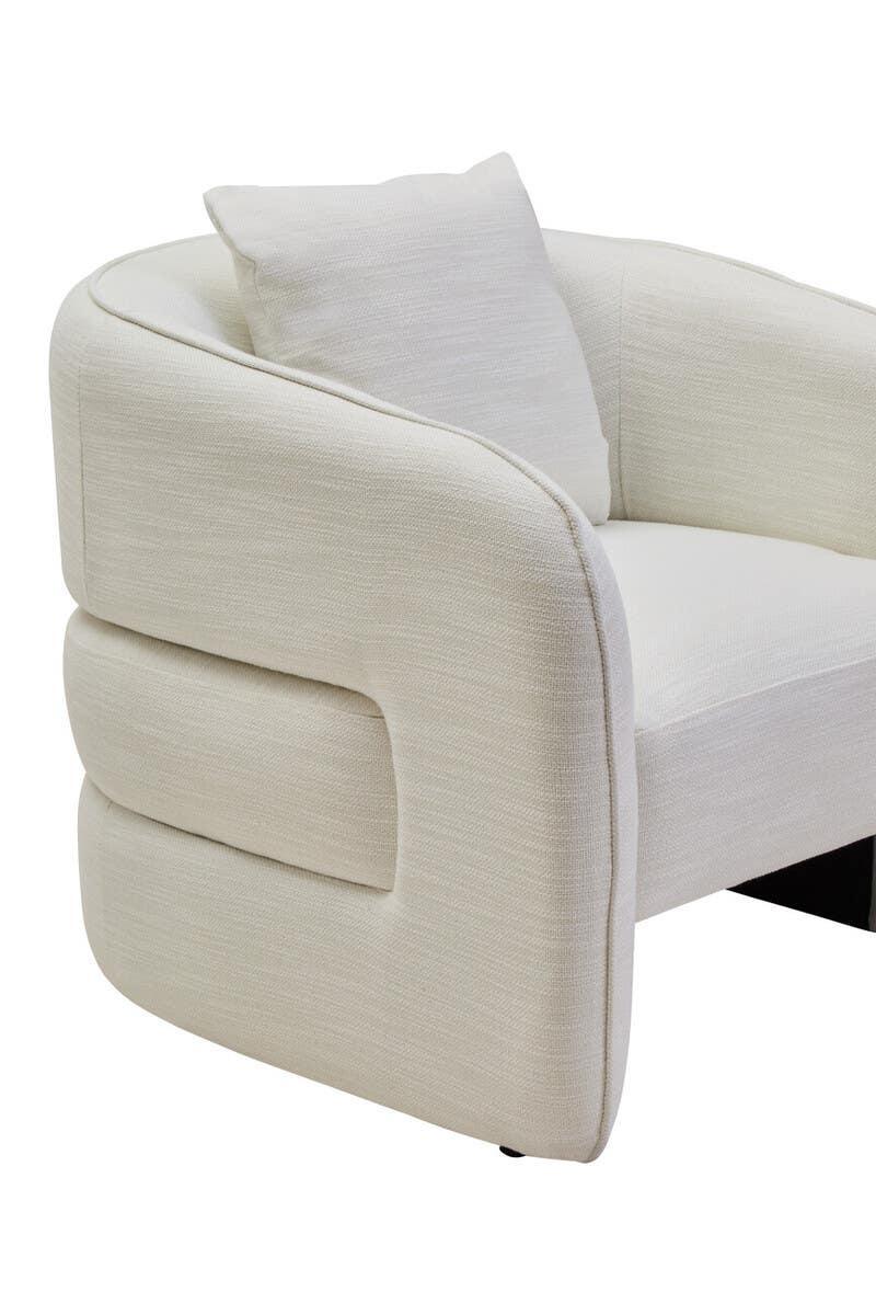 Cream fabric armchair with rounded backrest and matching cushion, close-up side view