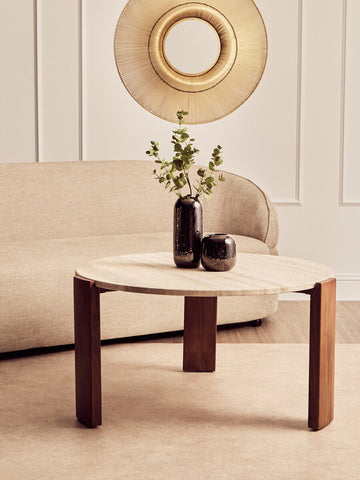 Round coffee table featuring a natural travertine marble top supported by sturdy acacia wood legs.