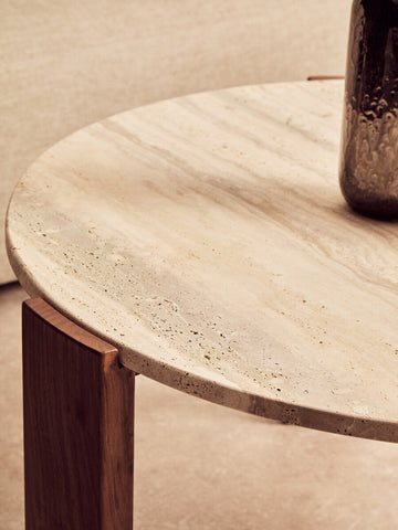Round coffee table featuring a natural travertine marble top with subtle variations in color and texture, supported by sleek acacia wood legs.