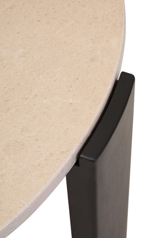 Close-up view of a round cream marble tabletop featuring subtle veining, seamlessly transitioning to a sleek black wooden leg that highlights the modern design.