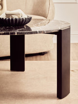 Round coffee table featuring a sleek black marble top with striking white veining, supported by sturdy black acacia wood legs.