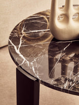 Round coffee table featuring a black marble top with striking white veining, complemented by sleek black wooden legs.