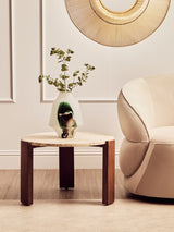 Round coffee table featuring a cream travertine marble top supported by sturdy acacia wood legs.