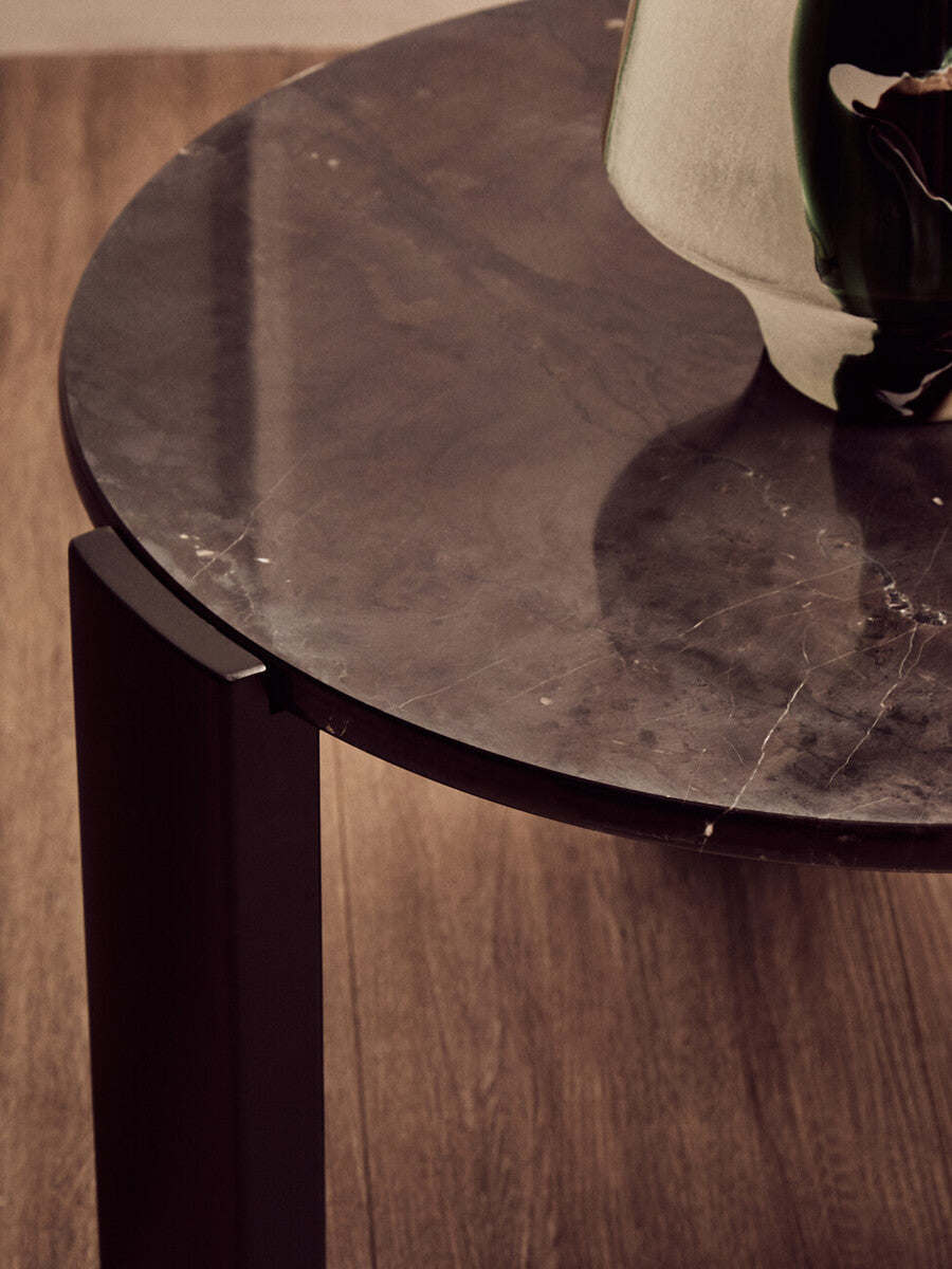 Round black marble top coffee table featuring a sleek design with a smooth surface and subtle veining, supported by sturdy acacia wood legs.