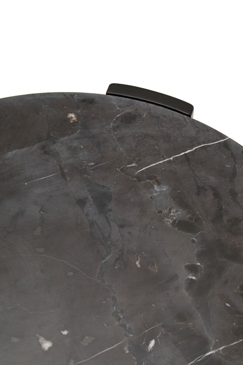 Close-up view of a round black marble tabletop featuring a smooth surface with subtle white veining and natural variations.