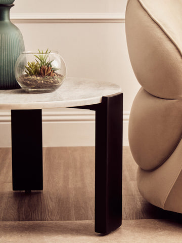 Round white marble top coffee table featuring a sleek black acacia wood base.