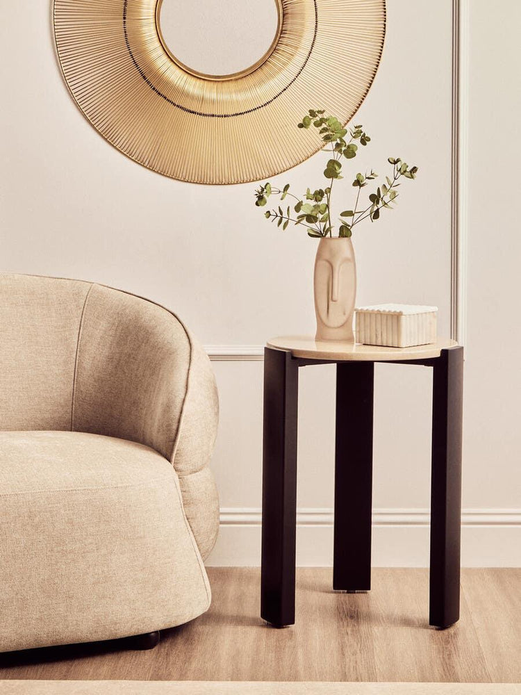 Modern side table with black legs and wood top beside beige sofa, minimalist vase and books