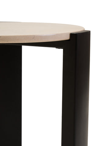Round side table featuring a cream marble top with subtle veining and a sleek black acacia wood base.