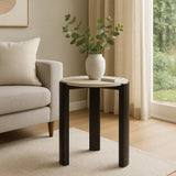 Round side table featuring a cream marble top and sleek black acacia wood legs.